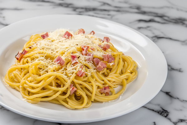 Plate with carbonara on marble table 